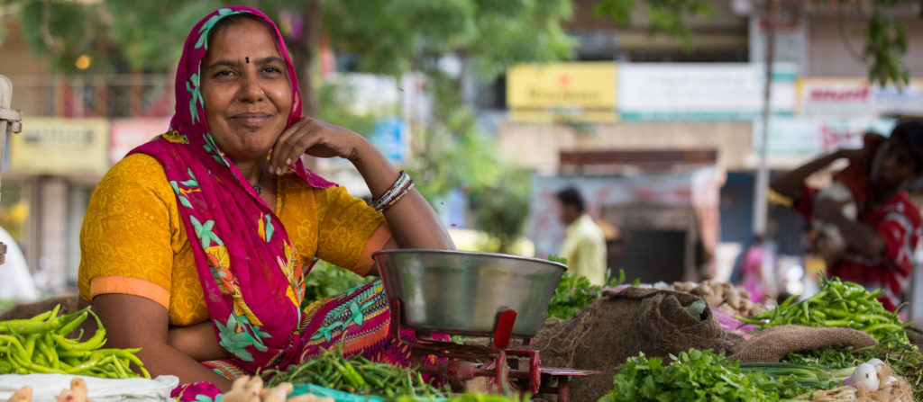 Choral Mauladia poses near by her cart where she sells vegetables at a local market. Street vendors face a number of difficulties, including harrassment from local officials and displacement by urban development projects. Given these threats, Choral joined the Self Employed Women's Association (SEWA), a trade union that works to secure the rights of workers in the informal sector.