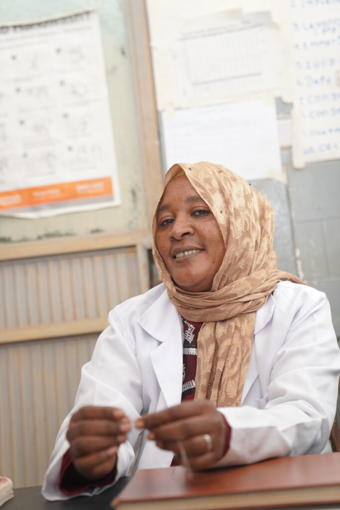 A healthcare worker in Ethiopia named Dahabo Gimbe sits behind her desk.