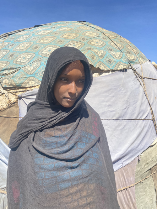 Ergo Humed, an Ethiopian mother, stands in front of her home.