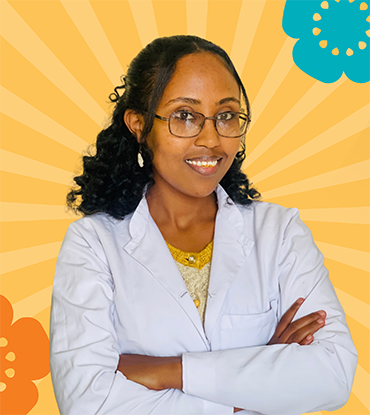 A young, female, Ethiopian doctor smiles at the camera.