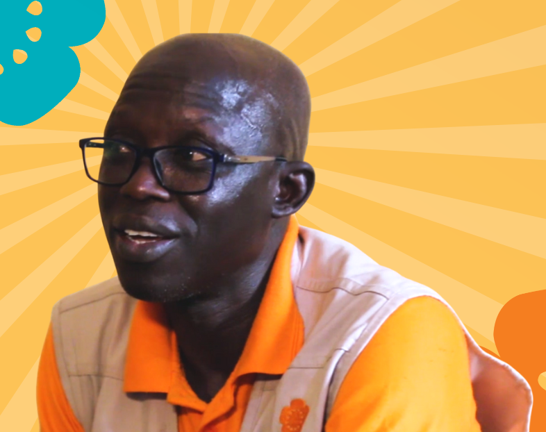 Nigerian Dr. Simon Audu speaks against a colorful background.