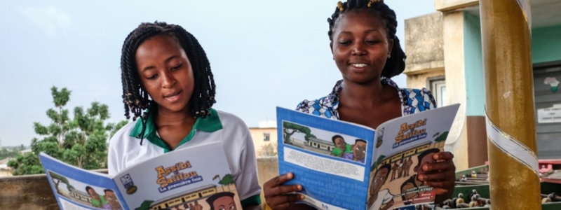 Two girls read EngenderHealth SRHR resources.