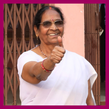 Portrait of retired nurse and adolescent health champion Manju Devi, giving a thumbs up to the camera, in Bihar, India.