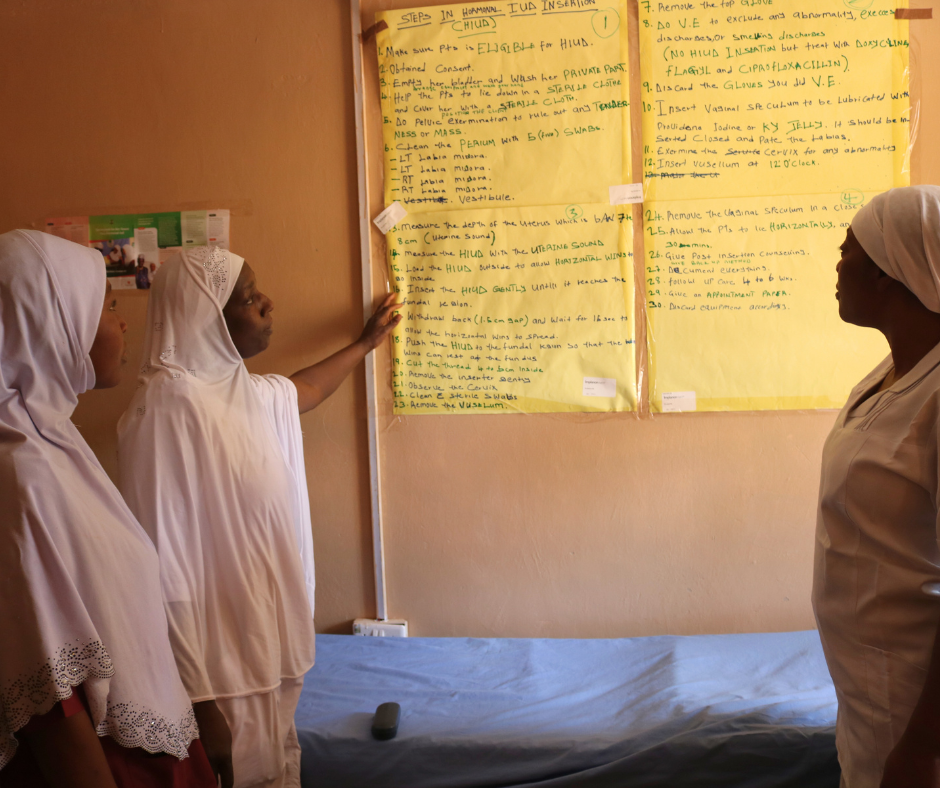 Three healthcare providers practice reviewing IUD insertion steps during a training to strengthen high-quality, voluntary contraceptive services. Photo courtesy of EngenderHealth Nigeria.