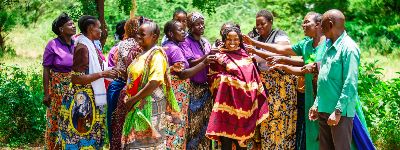 Community surrounds a smiling woman.