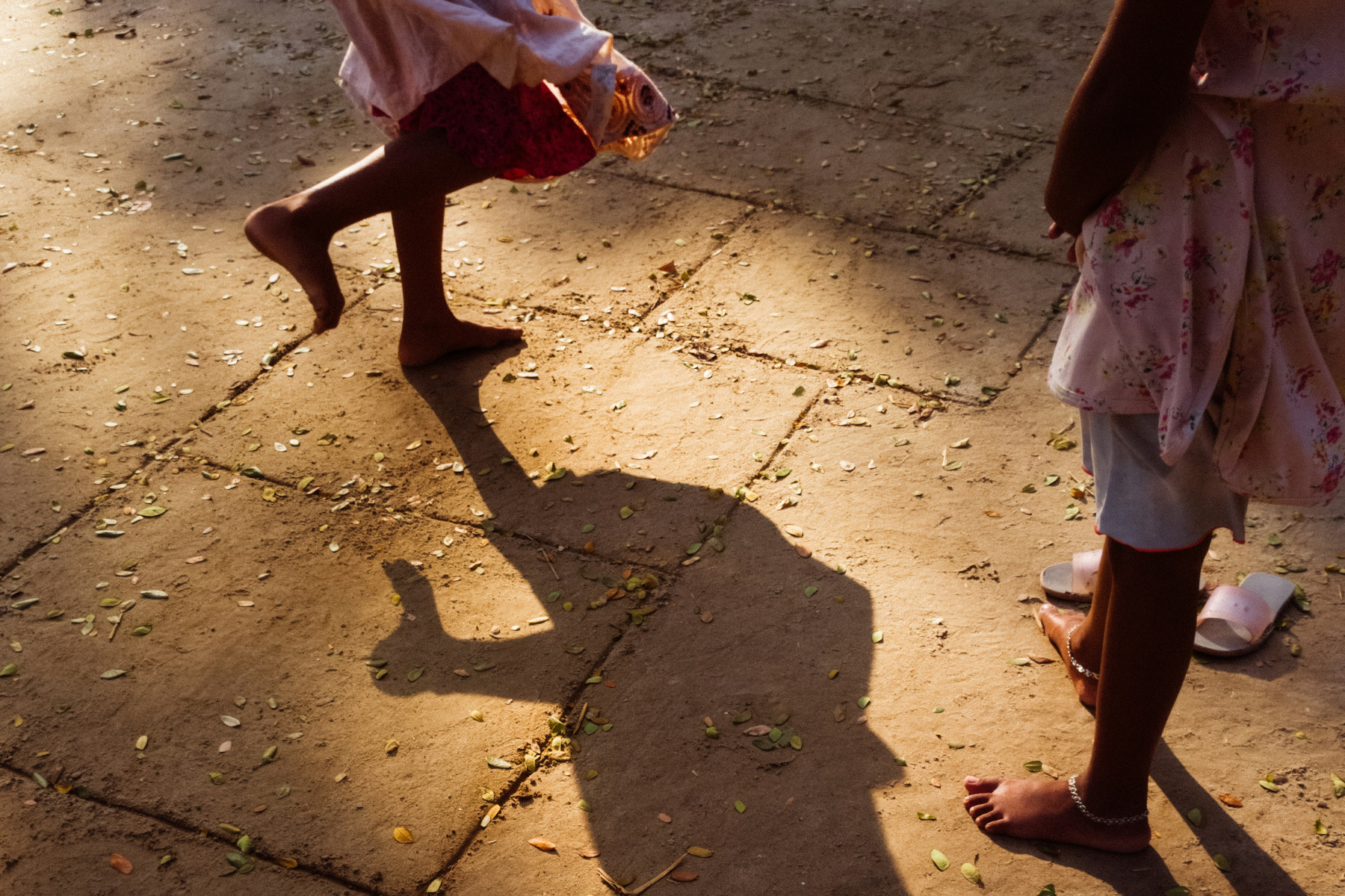 Shadows of two young girls playing in Bangladesh.