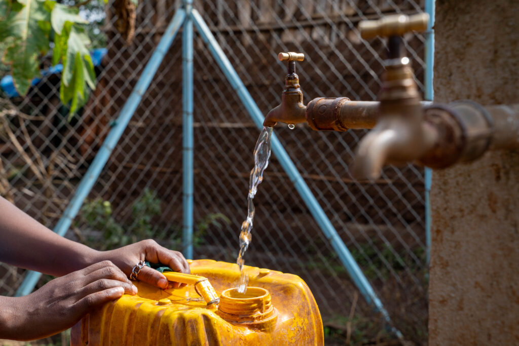 A water jug is filled at a clean water source supported through the REACH project in Ethiopia. Access to clean water helps health facilities improve hygiene, prevent infections, and provide safer care.