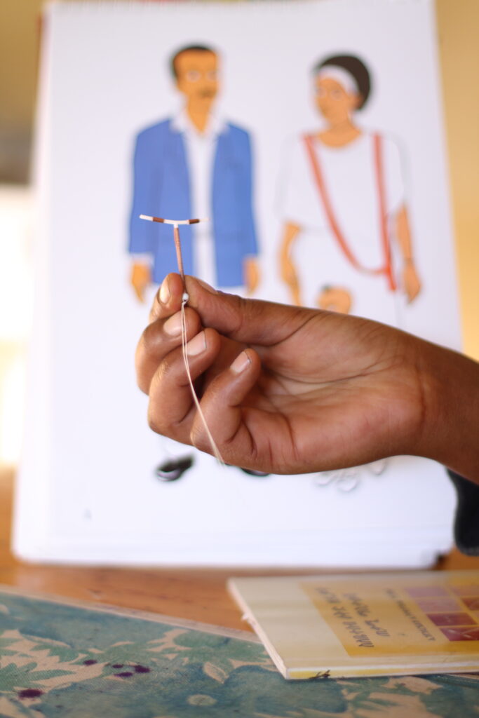 Photo of a hand holding a intrauterine contraceptive device (IUCD).