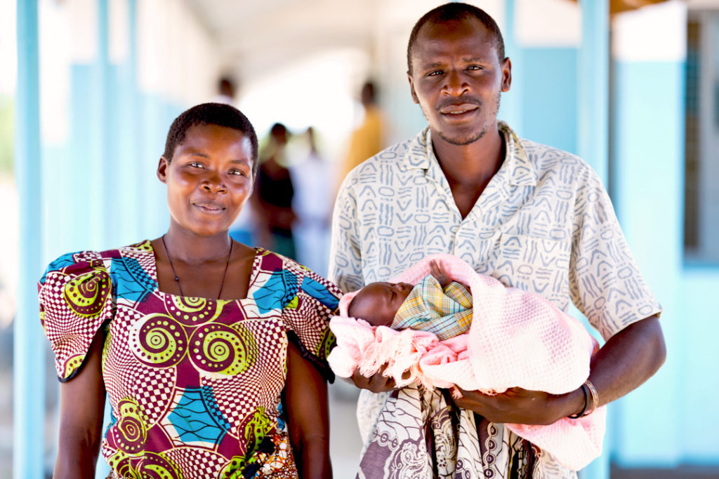 Mother and father hold their newborn baby in Tanzania.
